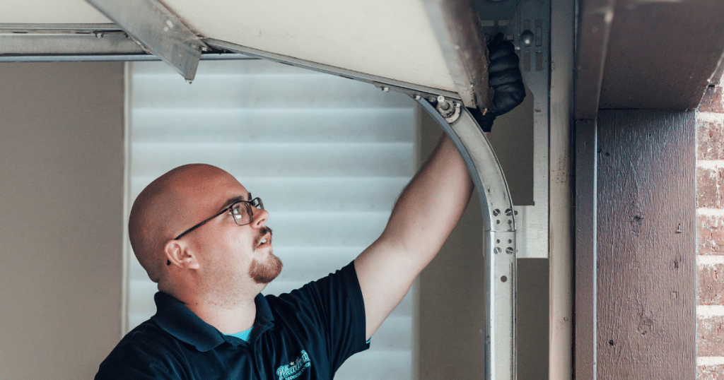 Technician inspects garage door track closely.