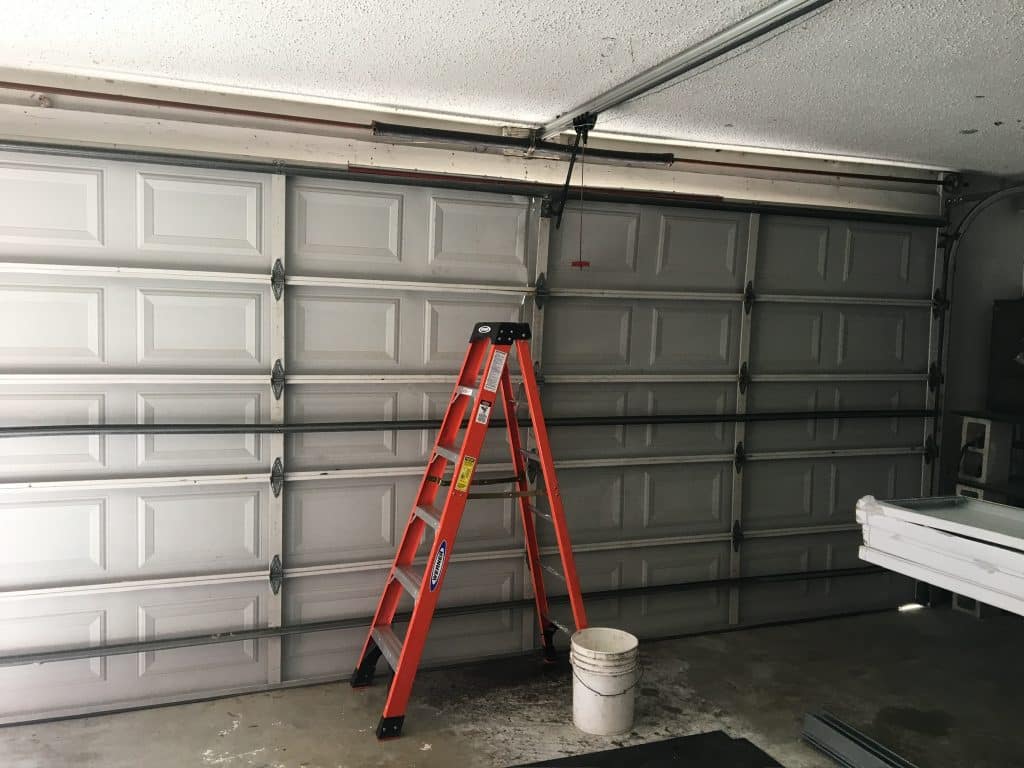 Ladder set up beneath closed garage door.