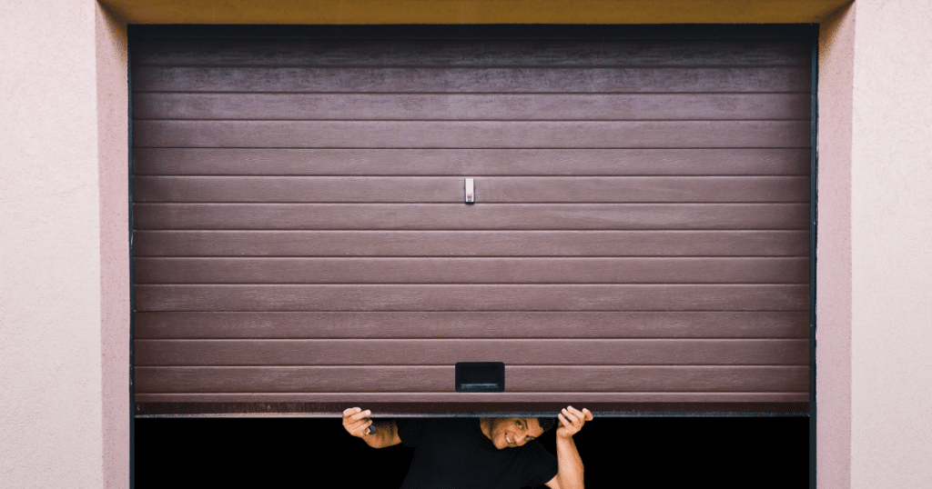 Man lifts brown garage door by hand.