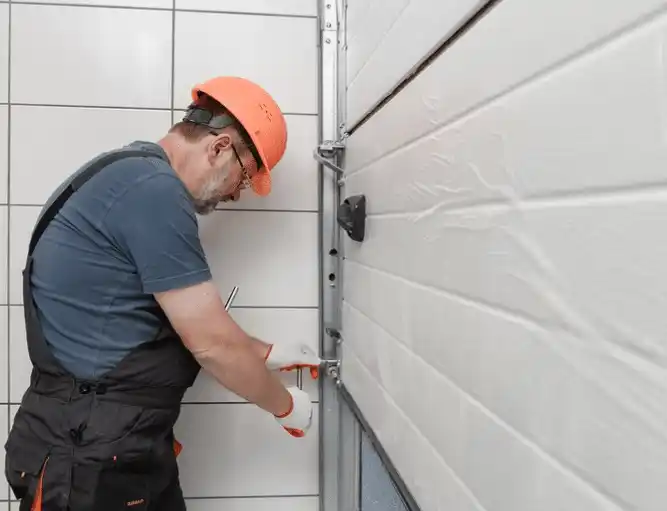 Worker installing garage door mechanism.
